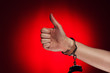 hand with thumb up and handcuffs opened concept