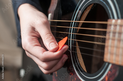 Photo: Female hand playing acoustic guitar.guitar play. Female hand playing acoustic guitar.guitar play.