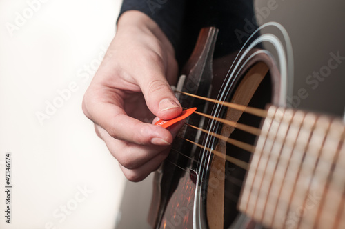 Photo: Female hand playing acoustic guitar.guitar play. Female hand playing acoustic guitar.guitar play.
