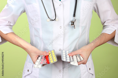 Photo: Close-up of female doctor hand holding pills, Close-up of female doctor hand holding pills,