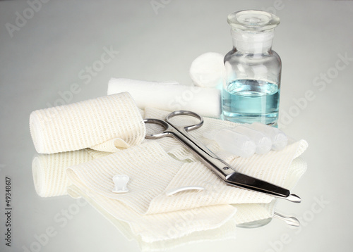 Photo: First aid kit for bandaging on grey background First aid kit for bandaging on grey background