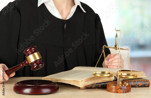 Photo: Judge sitting at table during court hearings on room background Judge sitting at table during court hearings on room background
