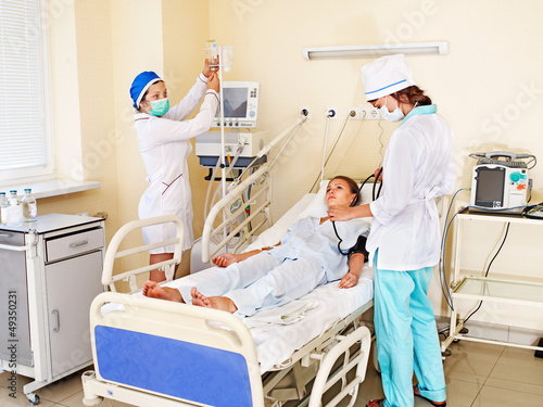 Photo: Doctor treats female patient with stethoscope. Doctor treats female patient with stethoscope.