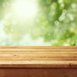 Empty wooden deck table with foliage bokeh background