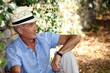 Elderly man sitting against the stone wall
