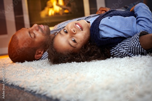 Photo: Little girl and father lying on floor at home Little girl and father lying on floor at home