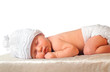 sleeping newborn baby girl in white hat wearing diaper