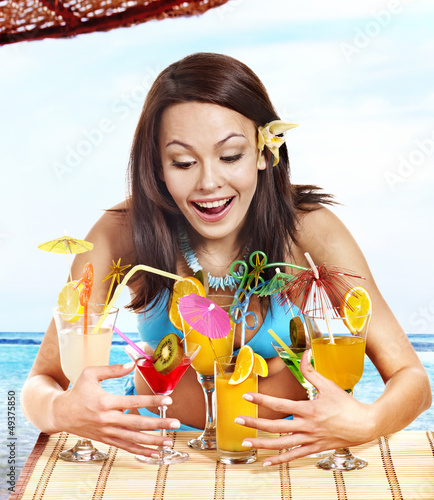 Photo: Girl in bikini on beach drinking cocktail. Girl in bikini on beach drinking cocktail.