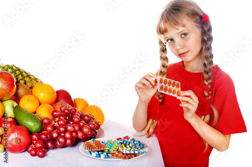 Photo: Child with fruit and vitamin pill. Child with fruit and vitamin pill.