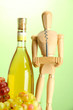 Mannequin with corkscrew and wine bottle, on green background
