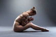 Sexy young woman with shibari sitting on floor