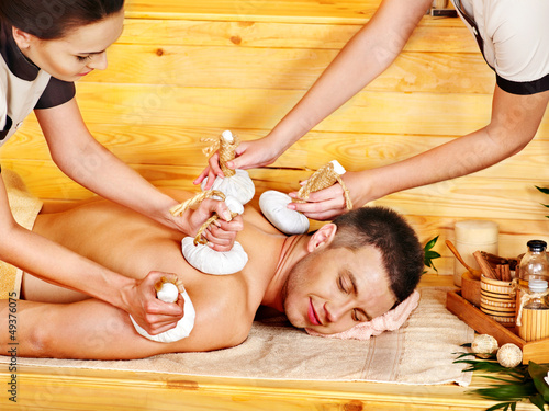 Photo: Man getting herbal ball massage treatments . Man getting herbal ball massage treatments .