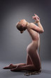 Slim nude woman posing with shibari in studio