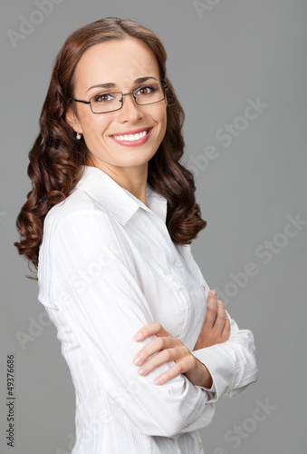 Photo: Smiling businesswoman, over gray Smiling businesswoman, over gray