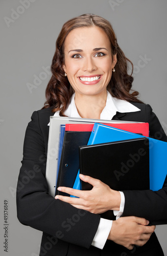 Photo: Businesswoman with folders, on gray Businesswoman with folders, on gray
