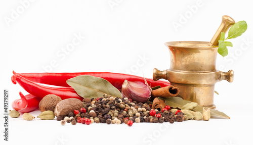 Photo: brass mortar and spices isolated on white brass mortar and spices isolated on white
