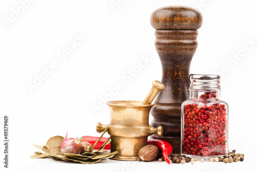 Photo: brass mortar with salt shaker and spices isolated on white brass mortar with salt shaker and spices isolated on white