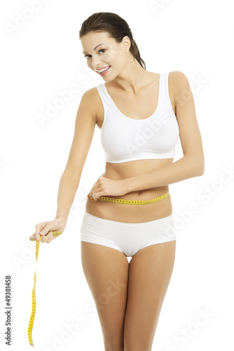 Photo: Happy young woman measuring her waist Happy young woman measuring her waist
