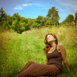 Photo: Young brunette woman relaxing in a sunny field Young brunette woman relaxing in a sunny field
