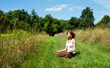 Photo: Young woman in lotus position meditating in nature Young woman in lotus position meditating in nature