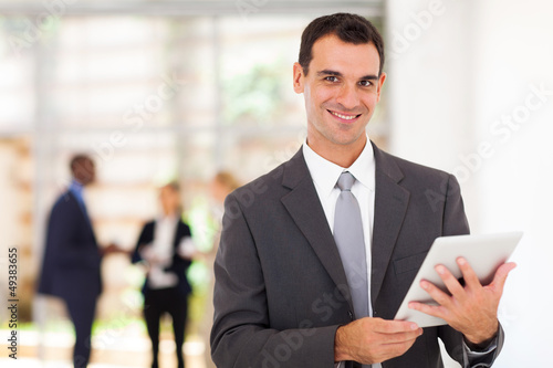 Photo: handsome businessman with tablet computer in office handsome businessman with tablet computer in office