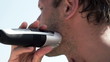 Man shaving beard with electric shaver, super slow motion