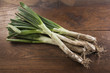 Photo: Bunch of calçots on wooden table Bunch of calçots on wooden table