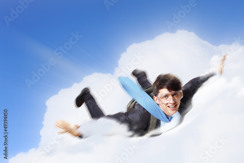 Photo: Young businessman flying with parachute on back Young businessman flying with parachute on back