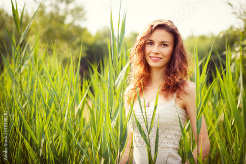 Photo: Portrait of beautiful woman in green grass Portrait of beautiful woman in green grass