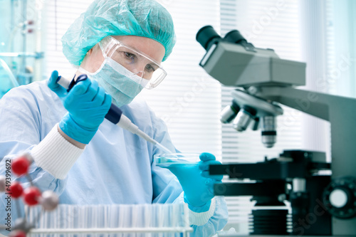 Photo: Scientist with dropper at the laboratory Scientist with dropper at the laboratory