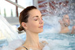 Woman enjoying hydrojet shower in spa pool