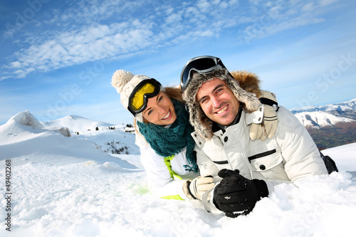 Photo: Couple of skiers laying down in the snow Couple of skiers laying down in the snow