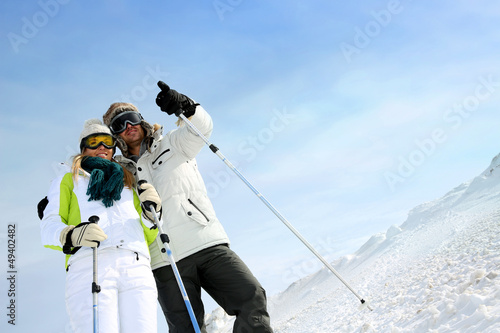 Photo: Coupl eof skiers on ski run looking at panorama Coupl eof skiers on ski run looking at panorama