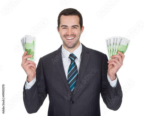 Photo: Excited businessman holding euro notes Excited businessman holding euro notes