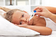 Photo: Sick little girl with thermometer laying in bed Sick little girl with thermometer laying in bed