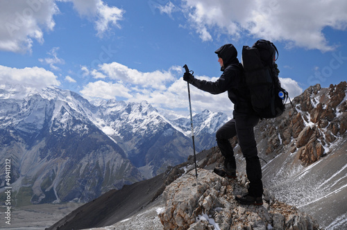 Photo: Young woman enjoys spectacular view to high mountains Young woman enjoys spectacular view to high mountains