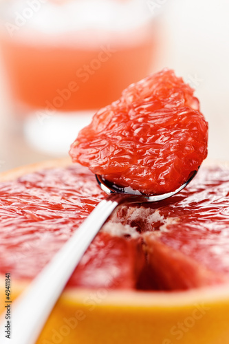 Photo: Citrus dessert - a piece of red grapefruit on the spoon Citrus dessert - a piece of red grapefruit on the spoon