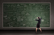 Thinking teacher in front of blackboard