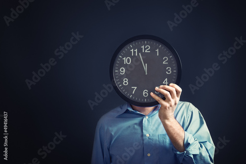 Photo: Businessman with black clock, deadline concept Businessman with black clock, deadline concept