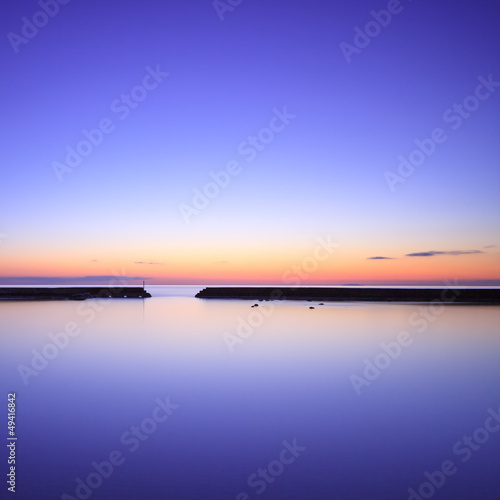 Photo: Concrete pier silhouette and blue ocean on twilight sunset Concrete pier silhouette and blue ocean on twilight sunset