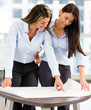 Business women looking at blueprints