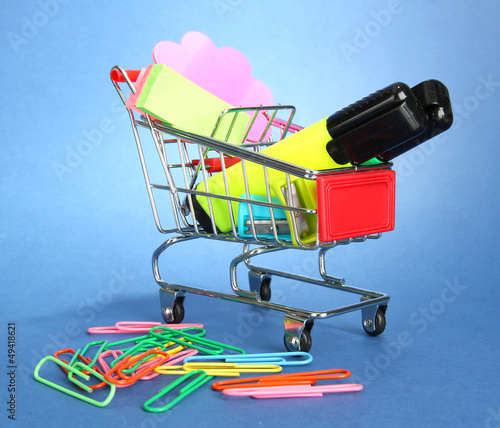 Photo: trolley with school equipment on blue background trolley with school equipment on blue background