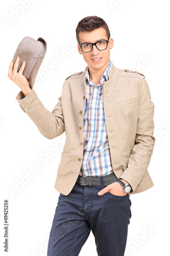 Photo: A young man holding a hat A young man holding a hat