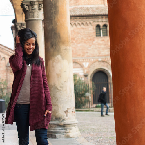 Photo: Young woman walking outdoors in s. Stephen, Bologna, Italy. Young woman walking outdoors in s. Stephen, Bologna, Italy.