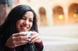 Young woman drinking coffee in a cafe outdoors. 