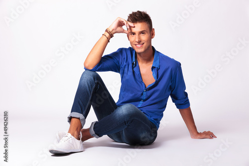 Photo: man with legs crossed holding forehead man with legs crossed holding forehead
