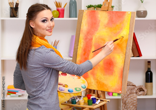 Photo: beautiful young woman painter at work, beautiful young woman painter at work,