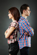 Portrait of sad young couple standing back to back