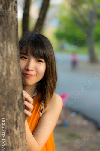 Photo: Cute Thai girl hiding behind the tree Cute Thai girl hiding behind the tree