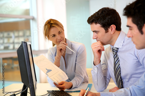 Photo: Business team working in front of desktop Business team working in front of desktop